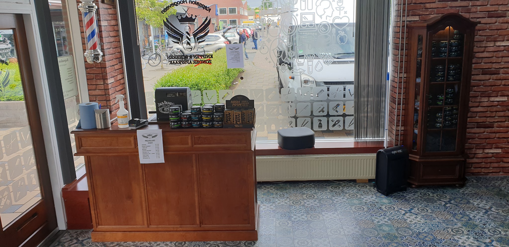 De houten toonbank van Kapsalon Hoogeveen bij het raam, met haar- en baardproducten